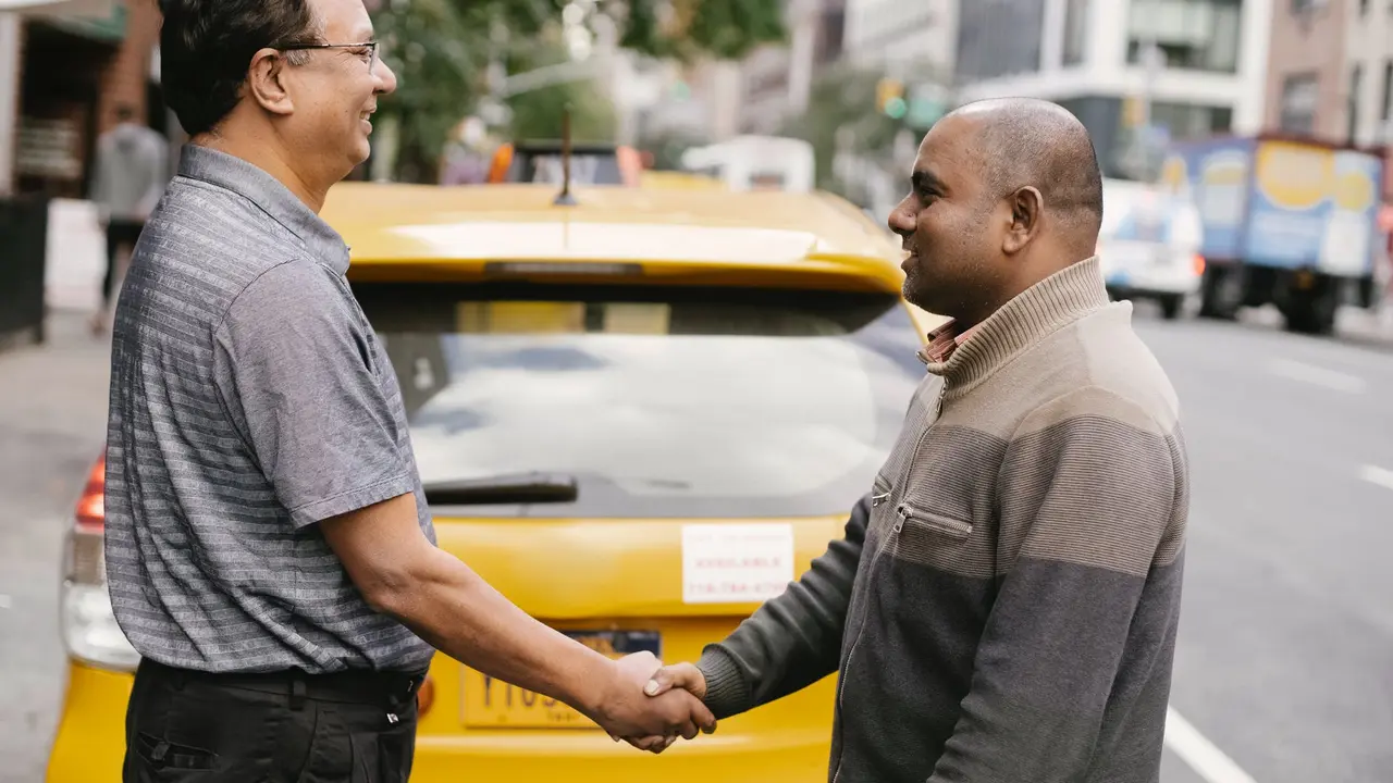 blue bowl of black bean beef tortilla soup on a board with cilantro and shredded cheese in background